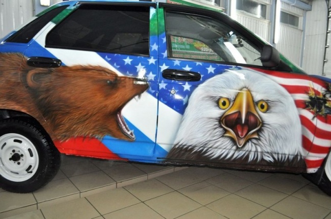 По правому боку машины-медведь,атакующий орла,на фоне горящего американского флага.