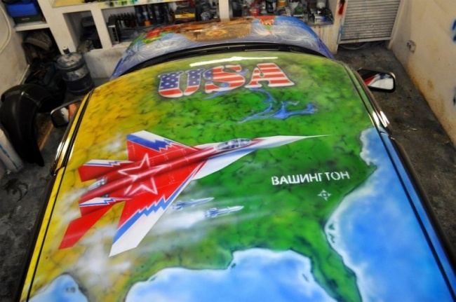 На крыше карта США,которую с воздуха бомбит русский самолет и надпись "Гудбай Америка".